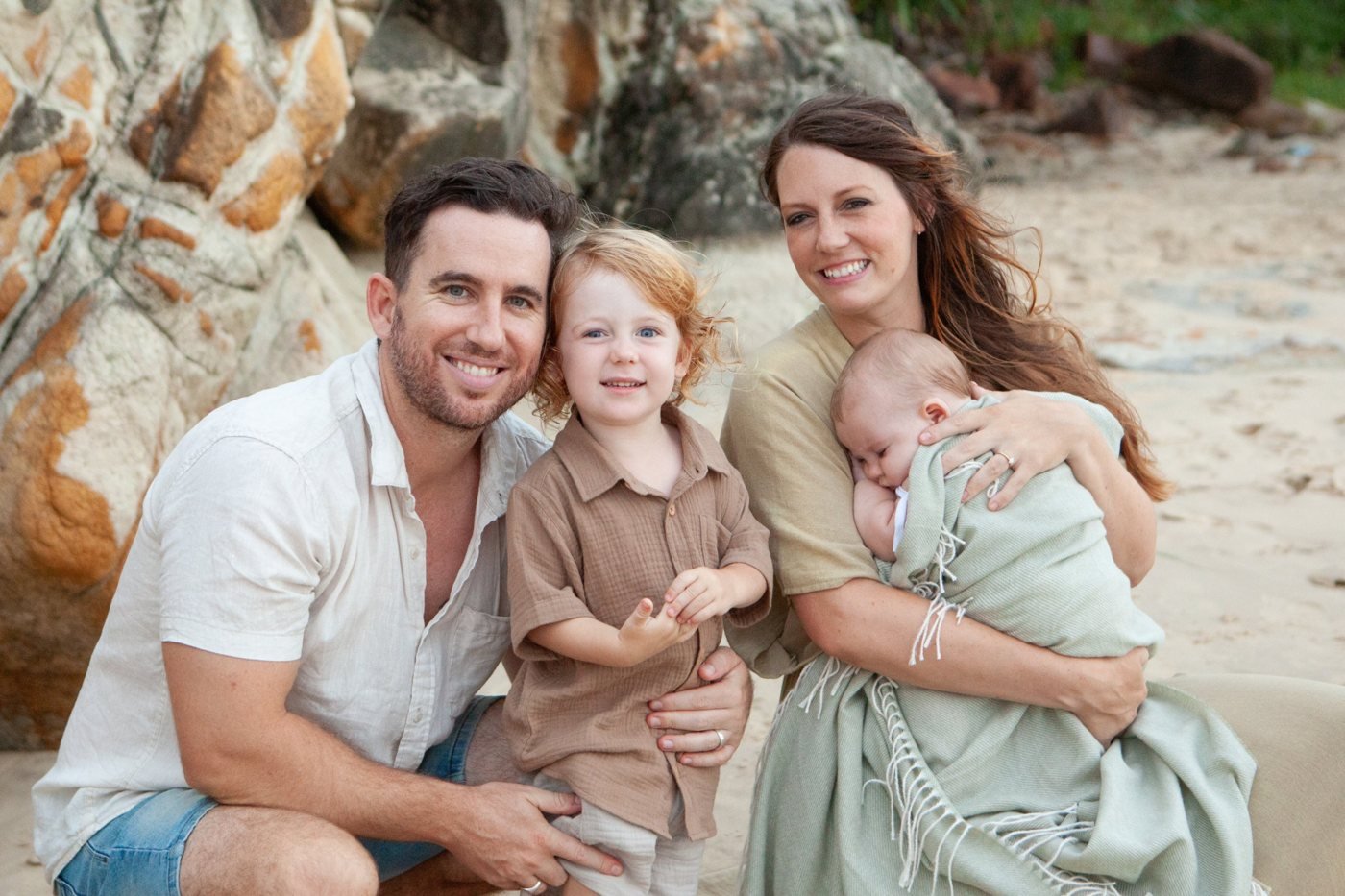 Kale Kneale with his wife and their two young sons on the beach
